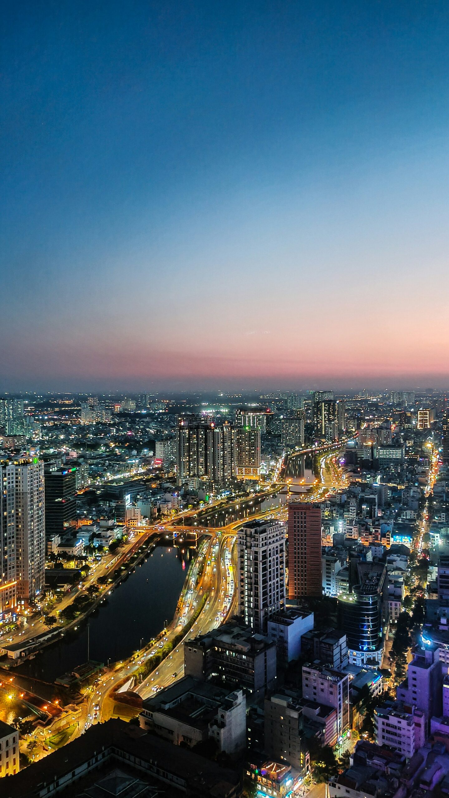 Ho Chi Minh City (Saigon) skyline at sunset, with the river separating District 1 and District 4.
